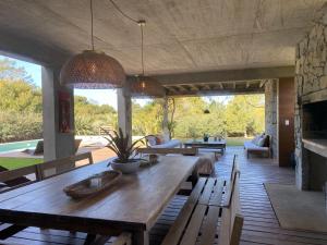 un soggiorno con tavolo e panche in legno di Casa de Piedra Village del Faro a José Ignacio