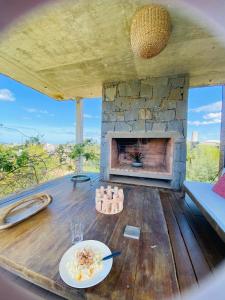 un tavolo con piatto di cibo e un camino di Casa de Piedra Village del Faro a José Ignacio