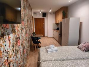 a small room with a bed and a kitchen at AmaMolto Gardens - włoskie apartamenty in Wrocław