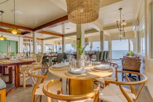 a dining room with tables and chairs and the ocean at Blue Reef Beach and Marina in Placencia