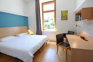 圣沙蒙L Hermitage的一间卧室，配有一张床、一张书桌和一扇窗户