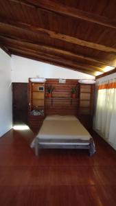 a bedroom with a bed and a wooden floor at Casa en Cataratas del Iguazú - GUEST HOUSE - in Puerto Iguazú