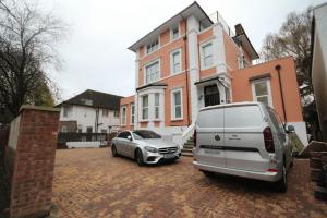 un furgone e un'auto parcheggiati davanti a una casa di Osterley Place - Apt B a Hounslow