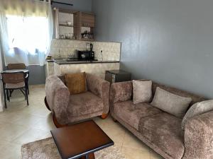 a living room with a couch and two chairs and a table at Aurora two in Kampala