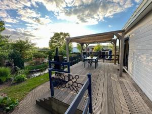 una terraza con una mesa y un banco en ella en Cozy escape near Den Bosch - 4 PS chalet met veel privacy en rust!, en Lith