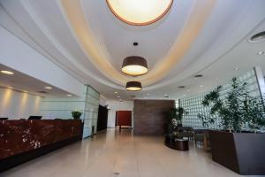 an office lobby with a large ceiling and a reception desk at Hotel Panamby Guarulhos in Guarulhos +24 photos