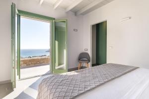 a bedroom with a bed and a view of the ocean at Villa Altheon Mykonos in Mykonos +113 photos