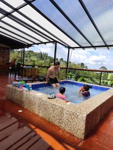 un uomo e due bambini in una piscina di VILLA EL EDEN GLAMPING Y CABAÑAS Cali a Cali Altre 48 foto