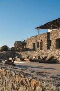 a row of benches in front of a stone building at Villa Altheon Mykonos in Mykonos
