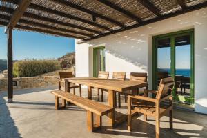 a wooden table and chairs on a patio at Villa Altheon Mykonos in Mykonos