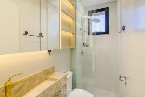 un bagno con doccia in vetro e WC di Aptos em prédio a 90 m da praia de Perequê - RIHs a Perequê Altre 51 foto