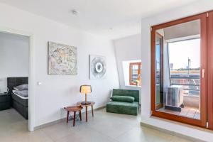 LUNIQ - Suite Marienborn mit Domblick - Klima - Parken في ليمبورغ ان دير لان: غرفة معيشة مع كرسي أخضر ونافذة