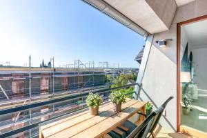 LUNIQ - Suite Marienborn mit Domblick - Klima - Parken في ليمبورغ ان دير لان: شرفة مع طاولة خشبية ونباتات الفخار