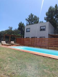 een huis met een zwembad voor een huis bij Cabañas del Sol in Punta Del Diablo