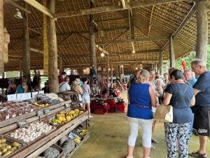 a group of people standing in an outdoor market at Saranya River House สรัญญาริเวอร์เฮาส์ in Mae Ai