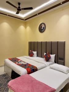 a room with two beds and a clock on the wall at Prabh palace in Ayodhya