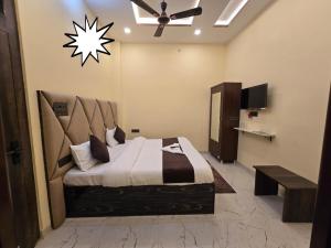a bedroom with a large bed and a ceiling fan at Prabh palace in Ayodhya +7 photos
