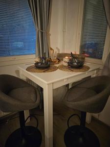 una mesa con dos sillas y una vela en ella en Nordic Nest Living., en Rovaniemi 2 fotos más