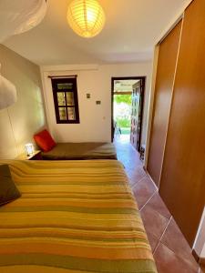 a bedroom with two beds and a hallway with a door at Les Sucriers in Les Anses-dʼArlets