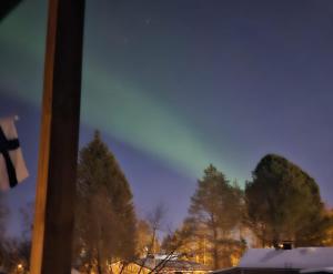 una ventana con vistas a un bosque nevado con árboles en Nordic Nest Living., en Rovaniemi