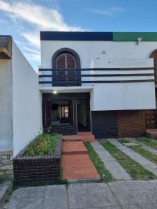 a white building with a window and a brick staircase at Duplex en mar de ajo Olivia in Mar de Ajó