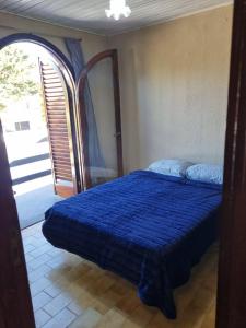 a bedroom with a bed with a blue comforter at Duplex en mar de ajo Olivia in Mar de Ajó