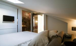a bedroom with a bed and a couch and a television at Arena's Hospitality in Verona