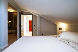 a bedroom with a white bed and a hallway at Arena's Hospitality in Verona
