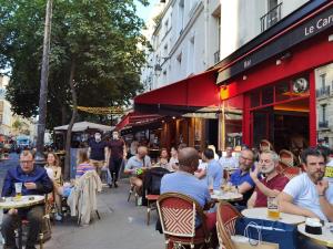 a group of people sitting at tables outside a restaurant at Studio Near Metro & Marais & Hotel de Ville & Seine in Paris