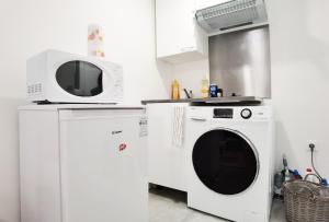 a kitchen with a washing machine and a microwave at Studio Near Metro & Marais & Hotel de Ville & Seine in Paris