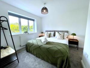 グロスターにあるBrand NEW 4-bedroom detached house - 20-min walk to Gloucester Docks - Ample Parking - Superfast Wi-Fi - Long-stay rates!のベッドと窓のある寝室