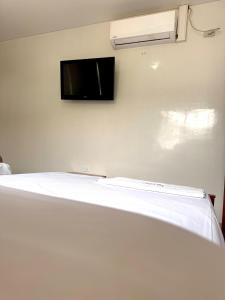 a room with a bed with a tv on the wall at Hostal la 200 in Floridablanca