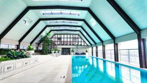 kryty basen w budynku z dużym sufitem w obiekcie Paxtonz Empire City Damansara Near One Utama w Kuala Lumpur