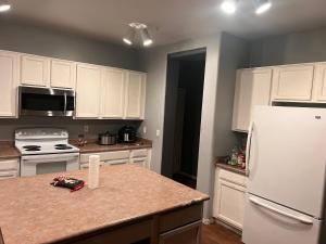 a kitchen with white cabinets and a white refrigerator at West Valley Spacious Room 2 94th in Phoenix +2 photos