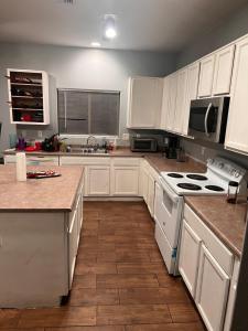 a kitchen with white cabinets and white appliances at West Valley Spacious Room 2 94th in Phoenix
