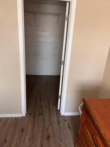 an empty closet with a door and a wooden floor at West Valley Spacious Room 2 94th in Phoenix