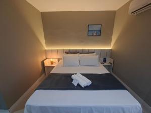 ein Schlafzimmer mit einem Bett mit zwei Handtüchern darauf in der Unterkunft Estadia com piscina e sauna a poucos passos da praia em Cabo Frio - HSC in Škorak + 27 Fotos