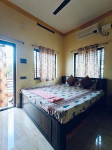 a bedroom with a bed in a room with windows at Balaji Homestay in Hampi