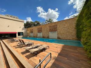 a group of lounge chairs sitting next to a swimming pool at Flat Hotel Mont Blanc Premium in Ribeirão Preto