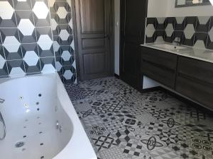 a bathroom with a tub and a sink at Appartement duplex 180m² in La Bourboule