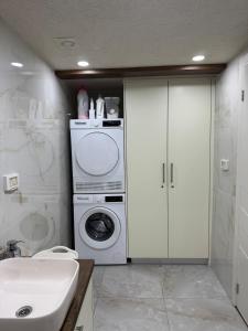 un bagno con lavatrice e lavandino di The Colony - By Lime Luxe a Haifa