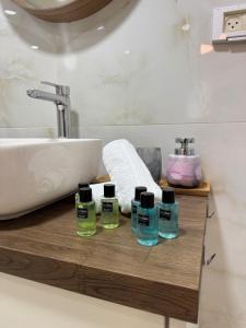 un bagno con lavandino e 4 bottiglie di sapone di The Colony - By Lime Luxe a Haifa Altre 11 foto