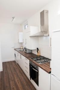 a kitchen with white appliances and wooden floors at Isleworth Apt C in Hounslow