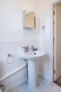 a white bathroom with a sink and a mirror at Isleworth Apt C in Hounslow +38 photos
