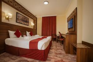 a hotel room with a bed and a television at Abraj Al Tayseer Tuwa Hotel in Makkah +105 photos