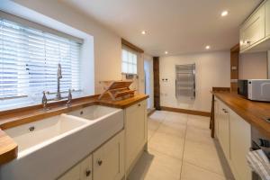 una cucina con un lavandino e una finestra di Charming 1 Bedroom Period Cottage in Sevenoaks a Chevening