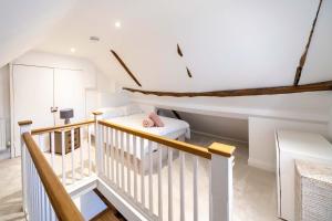una mansarda bianca con un letto e una scala di Charming 1 Bedroom Period Cottage in Sevenoaks a Chevening