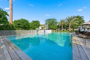 a large swimming pool with blue water at 3BR Luxurious Villa pool view DAMAC Hills 2 in Dubai