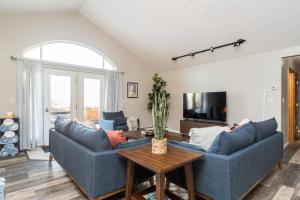 a living room with two blue couches and a table at Group Escape: 6BR Hot Tub, Sauna, Game Rm & Garage in Lemeta