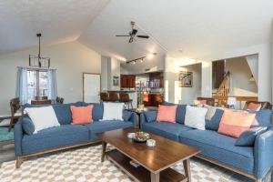 a living room with two blue couches and a table at Group Escape: 6BR Hot Tub, Sauna, Game Rm & Garage in Lemeta